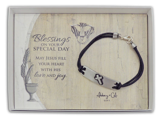 Bracelet with cross charm on a wooden card with text and Abbey & Co branding