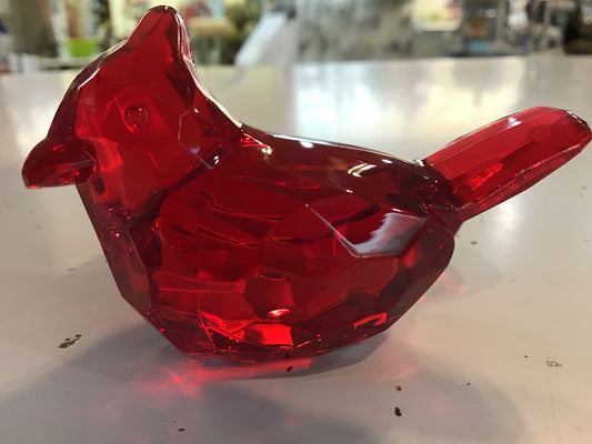 A red acrylic figurine of a cardinal bird.